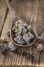 Wooden table with brown Rock Candy (close-up shot, selective focus)