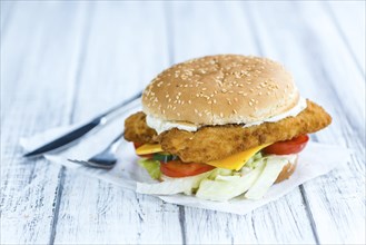 Fish Burger (selective focus, close-up shot) on wooden background