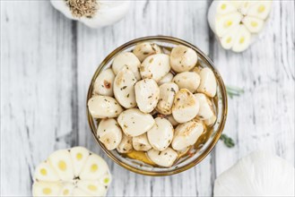 Portion of fresh Preserved Garlic (close-up shot, selective focus)