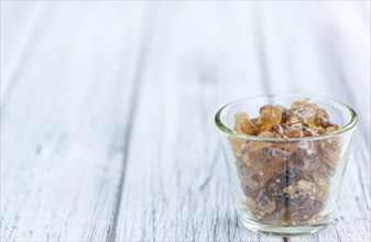 Wooden table with brown Rock Candy (close-up shot, selective focus)