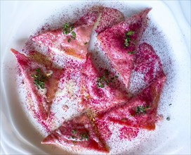 Restaurant Table with Beetroot Ravioli on a White Plate in Switzerland