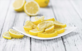 Fresh made Lemon (sliced) on an old and rustic wooden table (selective focus, close-up shot)