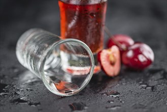 Portion of Cherry Liqueur on a rustic slate slab, selective focus, close-up shot