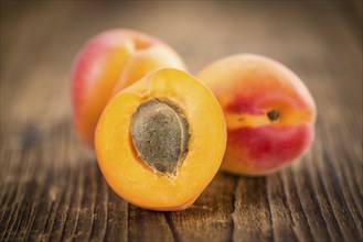 Fresh Apricots as high detailed close-up shot on a vintage wooden table (selective focus)