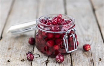 Vintage wooden table with Cranberries (preserved) (selective focus, close-up shot)