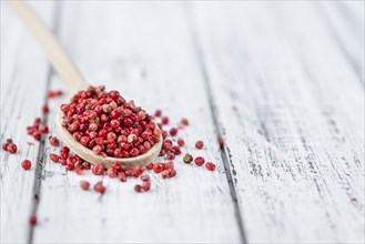 Pink Peppercorns on a vintage background as detailed close-up shot, selective focus