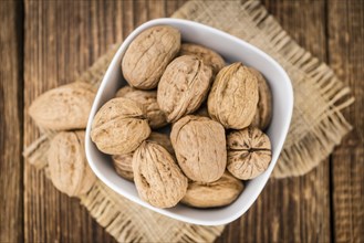 Walnuts on an old wooden table as detailed close-up shot (selective focus)