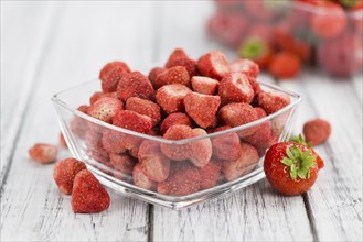 Dried Strawberries on rustic wooden background as close-up shot