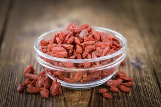 Goji Berries (dried) on an old wooden table as detailed close-up shot (selective focus)