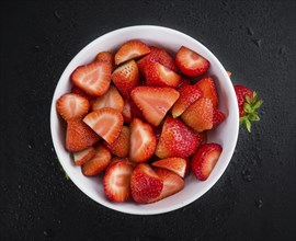 Some fresh Strawberries (Chopped) on a vintage slate slab, selective focus, close-up shot