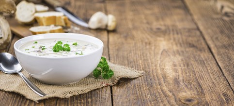 Porcini Soup on an old wooden table as detailed close-up shot, selective focus