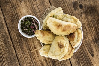 Portion of healthy Empanadas on an old wooden table (selective focus, close-up shot)