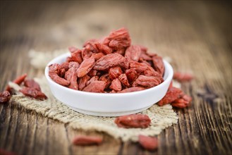 Goji Berries (dried) on an old wooden table as detailed close-up shot (selective focus)