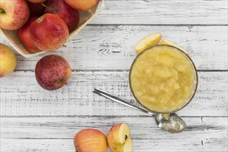 Homemade Applesauce (selective focus, close-up shot) on vintage background with some fresh fruits