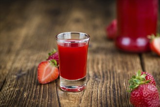 Fresh made Strawberry liqueur on an old and rustic wooden table, selective focus, close-up shot