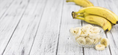 Sliced Bananas on an old wooden table as detailed close-up shot, selective focus