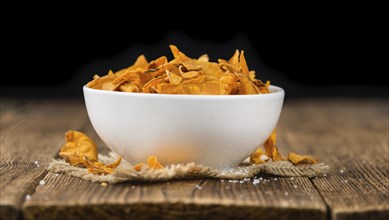 Sweet Potato Chips on an old wooden table as detailed close-up shot, selective focus