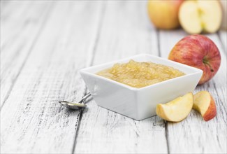 Old wooden table with fresh made Applesauce (selective focus, close-up shot)