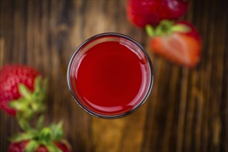 Fresh made Strawberry liqueur on an old and rustic wooden table, selective focus, close-up shot