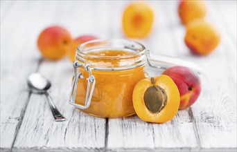 Apricot Jam on an old wooden table as detailed close-up shot (selective focus)