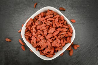 Some Dried Goji Berries on a slate slab (close-up shot, selective focus)