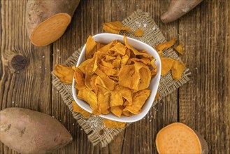 Sweet Potato Chips on a vintage background as detailed close-up shot, selective focus