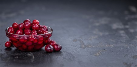 Healthy Canned Cranberries on a vintage slate slab (close-up shot, selective focus)