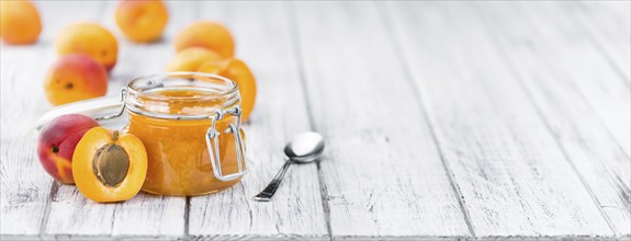 Apricot Jam on an old wooden table as detailed close-up shot (selective focus)