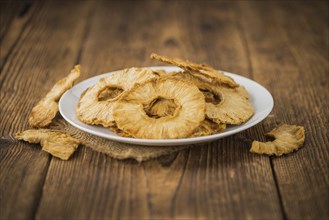 Pineapple rings (dried) on an old wooden table as detailed close-up shot, selective focus