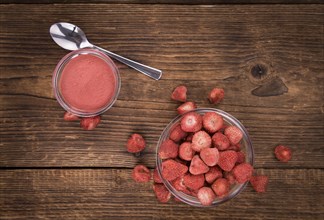 Strawberry powder as high detailed close-up shot on a vintage wooden table, selective focus