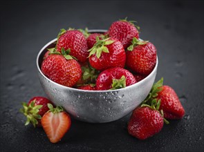 Portion of Strawberries as detailed close up shot on a slate slab, selective focus