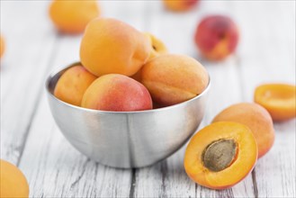Fresh Apricots as high detailed close-up shot on a vintage wooden table (selective focus)
