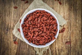 Goji Berries (dried) on an old wooden table as detailed close-up shot (selective focus)