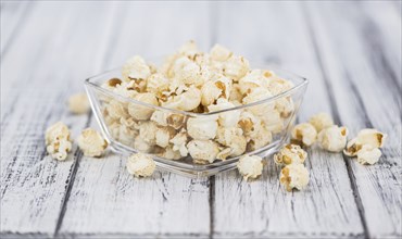 Fresh made Popcorn on an old and rustic wooden table, selective focus, close-up shot