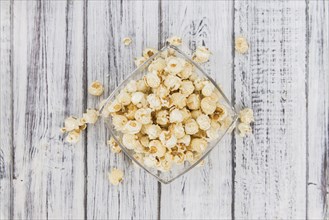 Fresh made Popcorn on a vintage background as detailed close-up shot