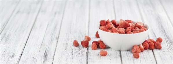 Dried Strawberries on rustic wooden background as close-up shot