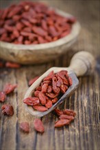 Goji Berries (dried) on an old wooden table as detailed close-up shot (selective focus)