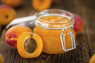 Apricot Jam on an old wooden table as detailed close-up shot (selective focus)