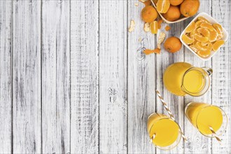 Homemade Tangerine Juice (close-up shot, selective focus) on a rustic background