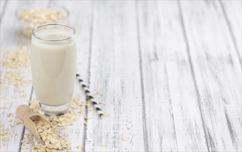 Healthy Oat Milk on a wooden table as detailed close-up shot (selective focus)