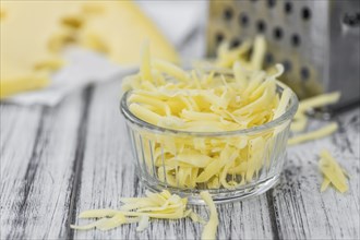 Old wooden table with grated Cheese (close-up shot)