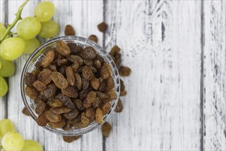 Wooden table with Raisins (detailed close-up shot, selective focus)