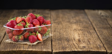 Strawberries on an old wooden table as detailed close-up shot, selective focus