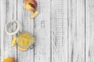 Old wooden table with fresh made Applesauce (selective focus, close-up shot)