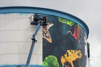 Detroit, Michigan, Workers wrap a new design on the water tower at the Detroit Zoo