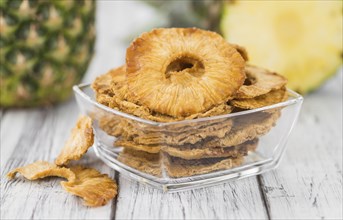 Pineapple rings (dried) on rustic wooden background as close-up shot