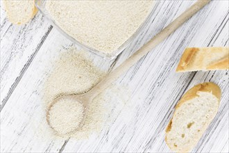 Some Bread Crumbs on a vintage wooden table (selective focus, close-up shot)