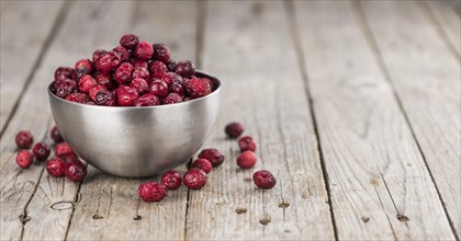 Dried Cranberries on an old wooden table (selective focus)