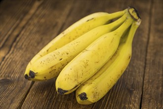 Whole Bananas on an old wooden table as detailed close-up shot, selective focus