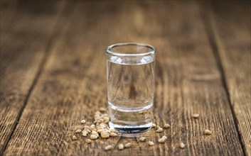 Wooden table with Wheat Liqueur (detailed close-up shot, selective focus)